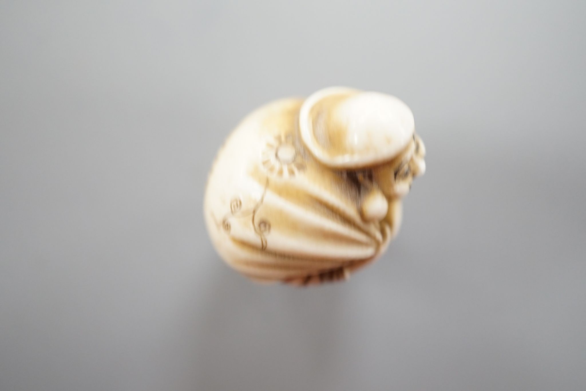 A Japanese ivory netsuke of Daikoku or Ebisu, Meiji period, 4 cms high.